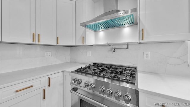 4452 Hamrock Ln, Osage Beach, MO 65065 - kitchen with stainless steel range with gas cooktop, wall chimney exhaust hood, white cabinets, backsplash, and light stone counters