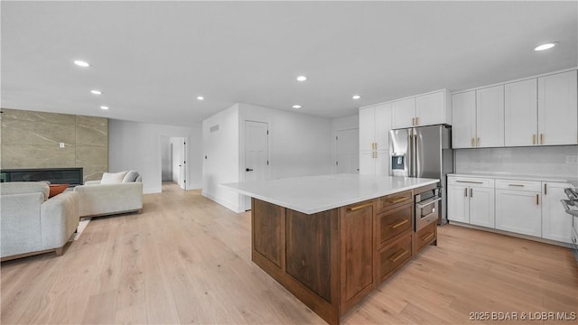 4452 Hamrock Ln, Osage Beach, MO 65065 - kitchen featuring white cabinetry, light countertops, light wood-style flooring, recessed lighting, and a center island