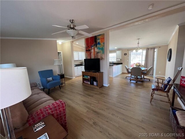 965 Four Waters Dr, Sunrise Beach, MO 65079 - living room featuring crown molding, light wood-style floors, ceiling fan, and a chandelier