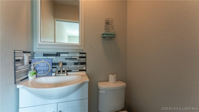 37 Hampton Bay Rd Unit 6, Eldon, MO 65026 - half bathroom with vanity, decorative backsplash, and a textured wall