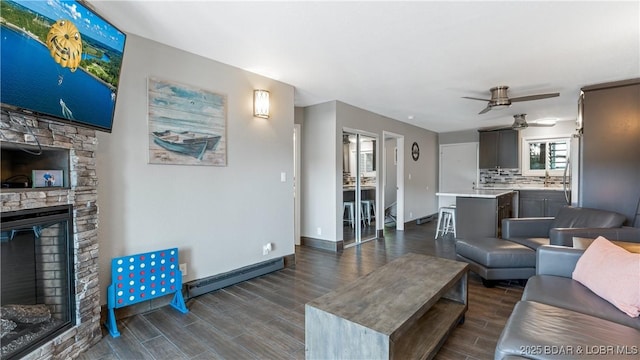37 Hampton Bay Rd Unit 6, Eldon, MO 65026 - living room with a ceiling fan, dark wood-style flooring, a stone fireplace, and a baseboard radiator