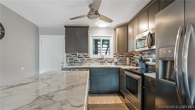 37 Hampton Bay Rd Unit 6, Eldon, MO 65026 - kitchen with stainless steel appliances, tasteful backsplash, ceiling fan, light stone countertops, and wood finished floors