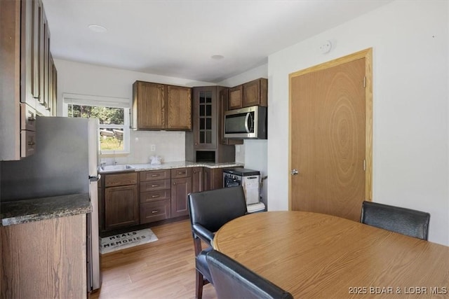 32655 Challenge Dr, Lincoln, MO 65338 - kitchen featuring stainless steel appliances, light wood finished floors, glass insert cabinets, and decorative backsplash