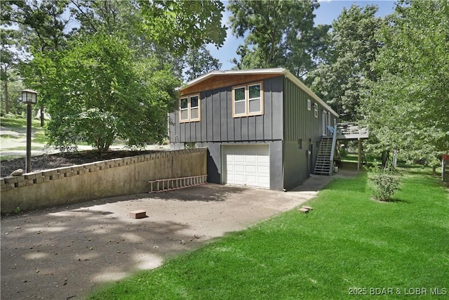 5109 Aqua Dr, Osage Beach, MO 65065 - view of home's exterior featuring stairs, driveway, an attached garage, a lawn, and board and batten siding
