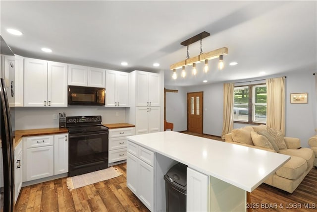 5109 Aqua Dr, Osage Beach, MO 65065 - kitchen featuring black appliances, white cabinetry, recessed lighting, dark wood-style floors, and open floor plan