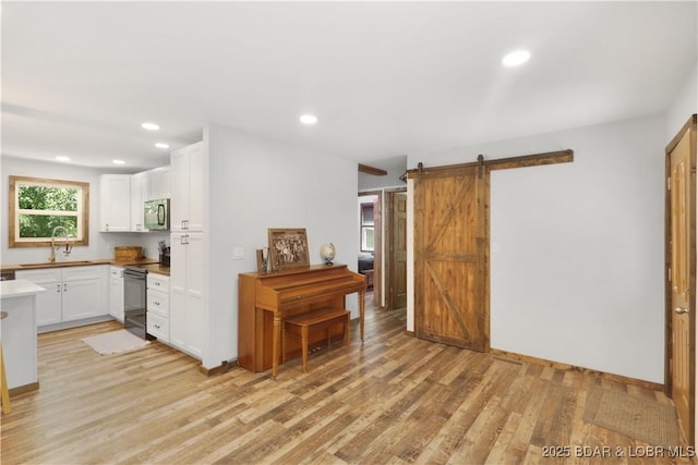 5109 Aqua Dr, Osage Beach, MO 65065 - kitchen with light wood-type flooring, white cabinets, a barn door, recessed lighting, and black electric range
