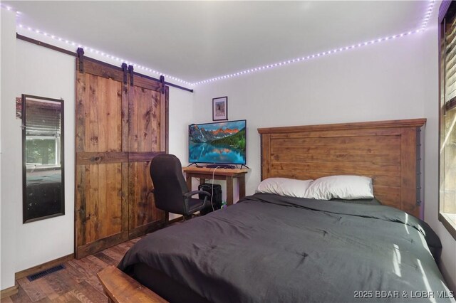 5109 Aqua Dr, Osage Beach, MO 65065 - bedroom featuring a barn door and wood finished floors
