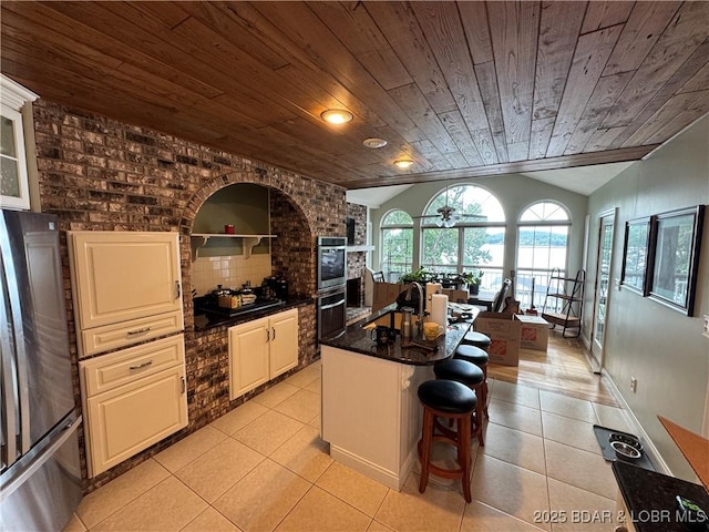 1215 Anemone Rd, Lake Ozark, MO 65049 - kitchen with appliances with stainless steel finishes, wood ceiling, lofted ceiling, light tile patterned floors, and a kitchen breakfast bar