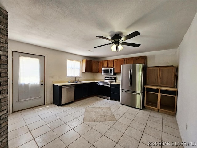 238 Foote Lane Rd, Eldon, MO 65026 - kitchen featuring stainless steel appliances, light countertops, ceiling fan, light tile patterned floors, and a textured ceiling