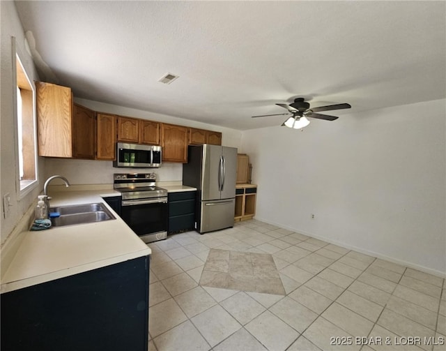 238 Foote Lane Rd, Eldon, MO 65026 - kitchen with appliances with stainless steel finishes, light countertops, ceiling fan, brown cabinets, and light tile patterned flooring