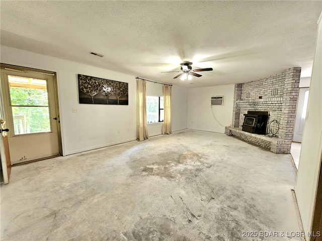 238 Foote Lane Rd, Eldon, MO 65026 - unfurnished living room featuring a textured ceiling, unfinished concrete flooring, ceiling fan, plenty of natural light, and an AC wall unit