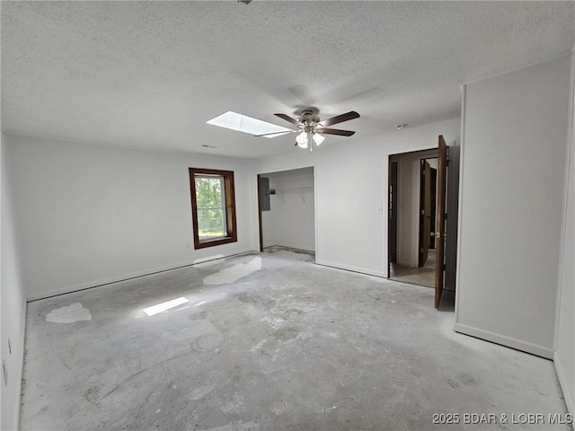 238 Foote Lane Rd, Eldon, MO 65026 - unfurnished bedroom featuring a textured ceiling, concrete floors, a skylight, a closet, and a ceiling fan