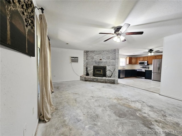 238 Foote Lane Rd, Eldon, MO 65026 - unfurnished living room with a brick fireplace, ceiling fan, a wall mounted air conditioner, a textured ceiling, and concrete flooring