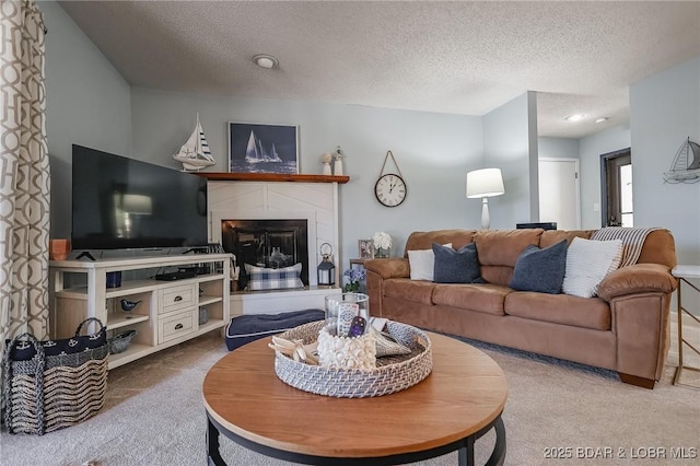 28 Eleven W Ct Unit 2A, Sunrise Beach, MO 65079 - living room with carpet floors, a glass covered fireplace, and a textured ceiling