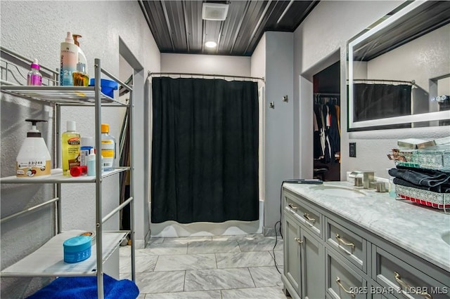 1972 Anderson Hollow Rd, Linn Creek, MO 65052 - bathroom with double vanity, a textured wall, shower / bath combo, and marble finish flooring