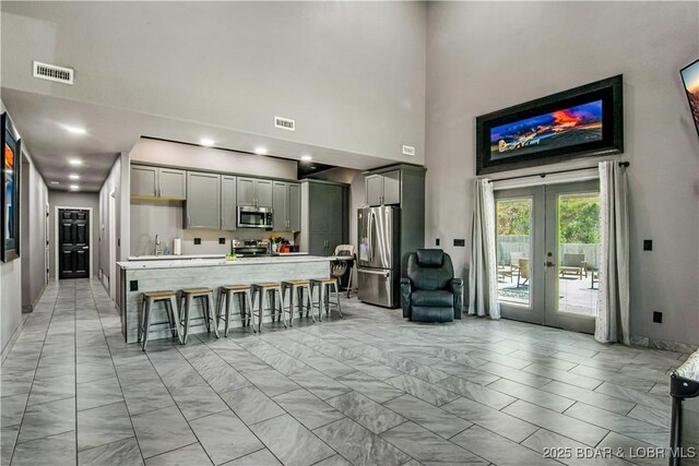 1972 Anderson Hollow Rd, Linn Creek, MO 65052 - kitchen featuring stainless steel appliances, light marble finish flooring, gray cabinets, a high ceiling, and french doors