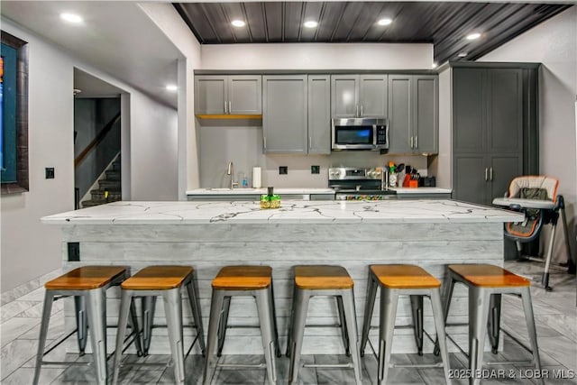 1972 Anderson Hollow Rd, Linn Creek, MO 65052 - kitchen with stainless steel appliances, gray cabinets, light marble finish floors, a kitchen breakfast bar, and recessed lighting
