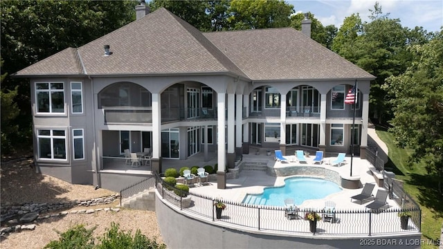 348 Cedar Crest Dr, Lake Ozark, MO 65049 - rear view of property featuring a balcony, a chimney, a patio, a fenced backyard, and a shingled roof