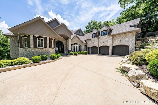 348 Cedar Crest Dr, Lake Ozark, MO 65049 - french country home featuring stone siding, concrete driveway, and a garage