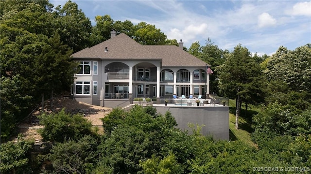 348 Cedar Crest Dr, Lake Ozark, MO 65049 - back of house with a balcony, a patio area, a chimney, and a swimming pool