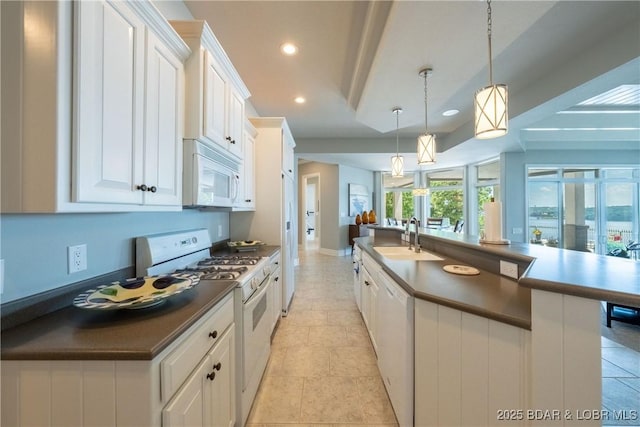 348 Cedar Crest Dr, Lake Ozark, MO 65049 - kitchen with white appliances, dark countertops, white cabinets, pendant lighting, and recessed lighting