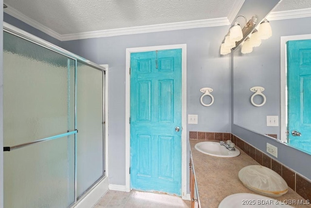 1123 Woodland Dr, Eldon, MO 65026 - bathroom featuring a shower with door, double vanity, a textured ceiling, and ornamental molding