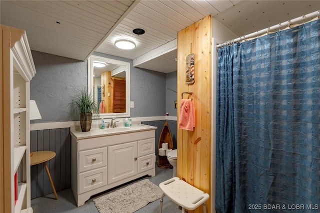 57 Ke Jo Point Rd, Gravois Mills, MO 65037 - full bathroom featuring finished concrete flooring, a textured wall, a wainscoted wall, vanity, and a shower with curtain
