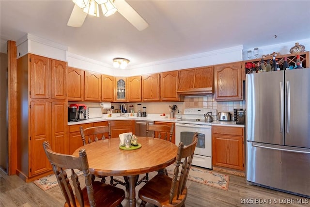 57 Ke Jo Point Rd, Gravois Mills, MO 65037 - kitchen featuring appliances with stainless steel finishes, light wood-style floors, a ceiling fan, and brown cabinetry