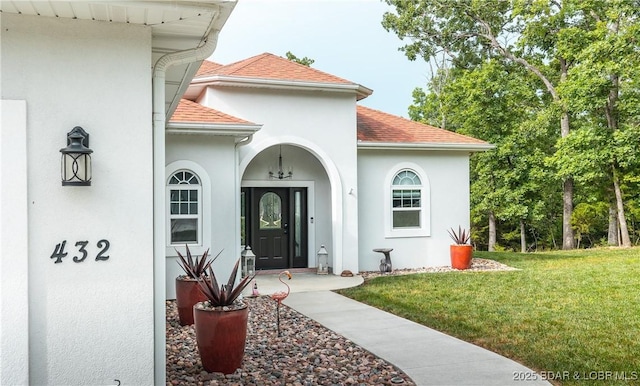 432 Cornett Branch Rd, Four Seasons, MO 65049 - view of exterior entry with stucco siding, roof with shingles, and a yard