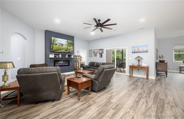432 Cornett Branch Rd, Four Seasons, MO 65049 - living room with arched walkways, ceiling fan, light wood-type flooring, recessed lighting, and a glass covered fireplace