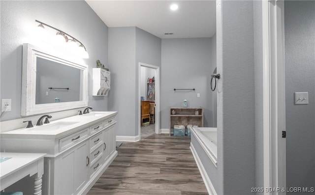 432 Cornett Branch Rd, Four Seasons, MO 65049 - bathroom featuring double vanity, a garden tub, wood finished floors, and a walk in closet