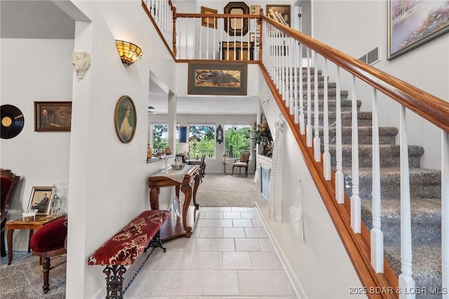 1008 Beacon Ridge Dr, Lake Ozark, MO 65049 - carpeted entrance foyer with a towering ceiling, stairway, and tile patterned floors
