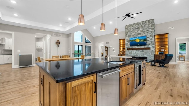 1254 Darwin Dr, Osage Beach, MO 65065 - kitchen featuring dishwasher, open floor plan, beverage cooler, dark countertops, and a center island with sink