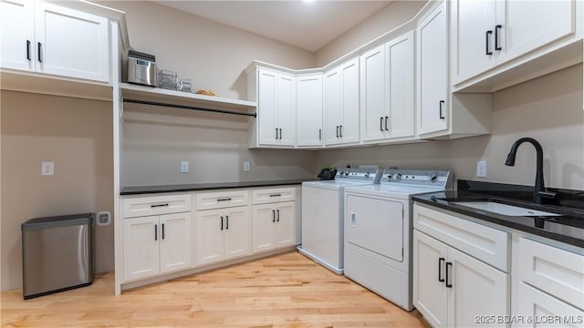 1254 Darwin Dr, Osage Beach, MO 65065 - laundry room with cabinet space, light wood-style flooring, and washing machine and clothes dryer