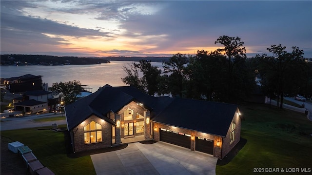 1254 Darwin Dr, Osage Beach, MO 65065 - modern inspired farmhouse with concrete driveway, a garage, a lawn, and stone siding