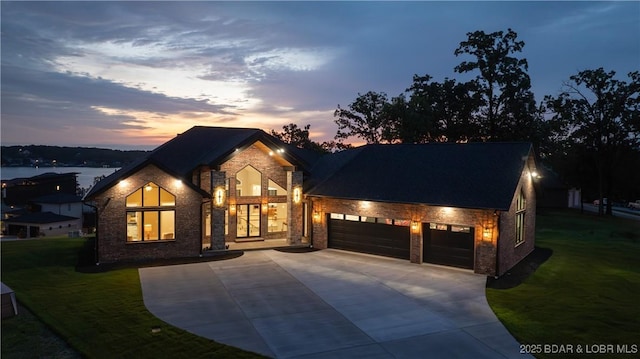 1254 Darwin Dr, Osage Beach, MO 65065 - view of front facade with a garage, driveway, a yard, brick siding, and stone siding