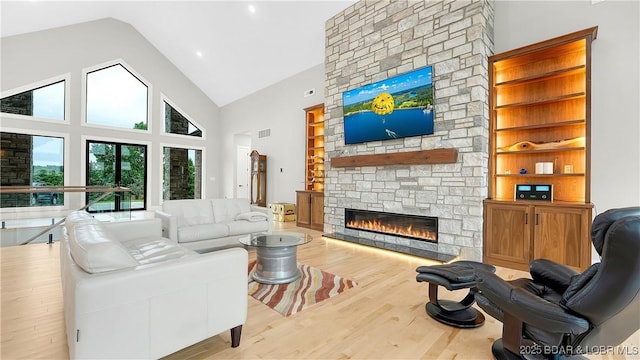 1254 Darwin Dr, Osage Beach, MO 65065 - living area featuring a fireplace, wood finished floors, high vaulted ceiling, built in shelves, and recessed lighting