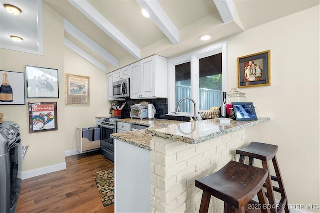 541 Elbow Cay Dr, Osage Beach, MO 65065 - kitchen with appliances with stainless steel finishes, white cabinets, a peninsula, a kitchen bar, and light stone countertops