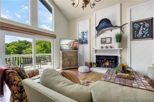 541 Elbow Cay Dr, Osage Beach, MO 65065 - living room featuring a chandelier, wood finished floors, a fireplace, and high vaulted ceiling