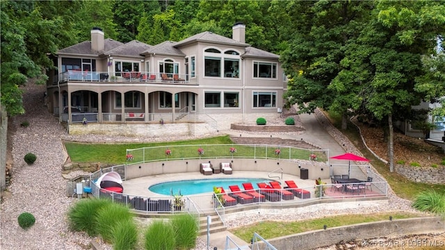 1453 Grand View Dr, Porto Cima, MO 65079 - back of house featuring a chimney, a patio area, a balcony, and stucco siding