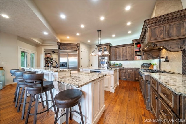 1453 Grand View Dr, Porto Cima, MO 65079 - kitchen featuring a large island with sink, stainless steel built in fridge, open shelves, backsplash, and hardwood / wood-style floors