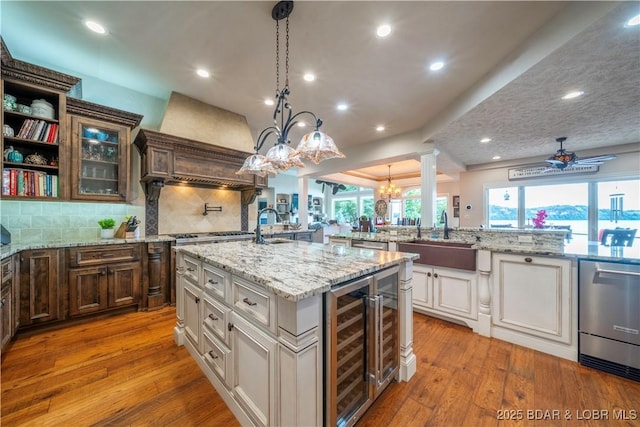 1453 Grand View Dr, Porto Cima, MO 65079 - kitchen with wine cooler, a chandelier, dishwasher, a large island with sink, and hardwood / wood-style floors