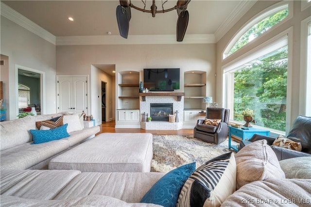 1453 Grand View Dr, Porto Cima, MO 65079 - living room featuring wood finished floors, ornamental molding, a glass covered fireplace, and a high ceiling