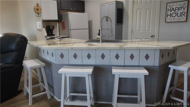 575 Park Place Dr Unit 2B, Kaiser, MO 65047 - kitchen with freestanding refrigerator, a breakfast bar, a peninsula, and dark wood-type flooring