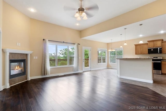 267 Cornett Branch Rd, Four Seasons, MO 65049 - unfurnished living room featuring healthy amount of natural light, a ceiling fan, a tiled fireplace, dark wood-style floors, and recessed lighting