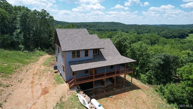 1378 Full Gallop Ln, Roach, MO 65787 - view of front facade with a forest view, driveway, a wooden deck, and a shingled roof