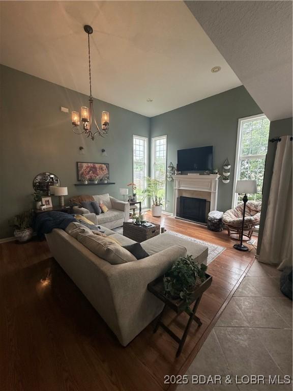 1720 Lakeview Dr, Chillicothe, MO 64601 - living area featuring a fireplace, a chandelier, vaulted ceiling, and wood finished floors