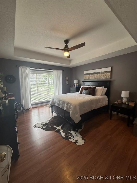 1720 Lakeview Dr, Chillicothe, MO 64601 - bedroom featuring a raised ceiling, wood finished floors, a textured ceiling, and a ceiling fan