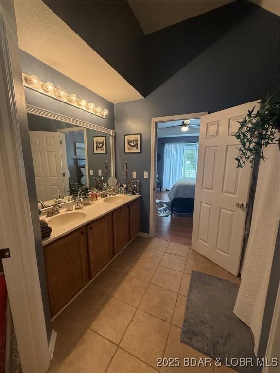 1720 Lakeview Dr, Chillicothe, MO 64601 - ensuite bathroom with tile patterned floors, double vanity, and vaulted ceiling
