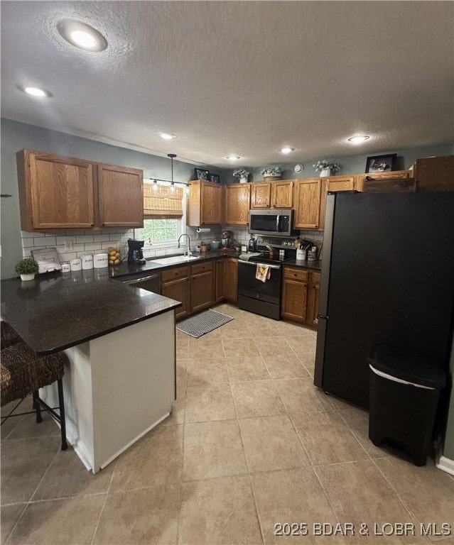 1720 Lakeview Dr, Chillicothe, MO 64601 - kitchen featuring appliances with stainless steel finishes, a peninsula, backsplash, dark countertops, and a textured ceiling
